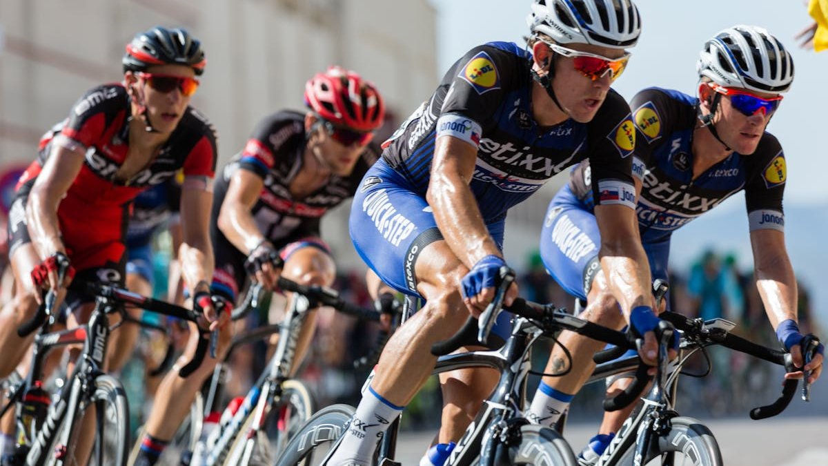 Peloton de cyclistes en course sur route, vélos carbone haut de gamme