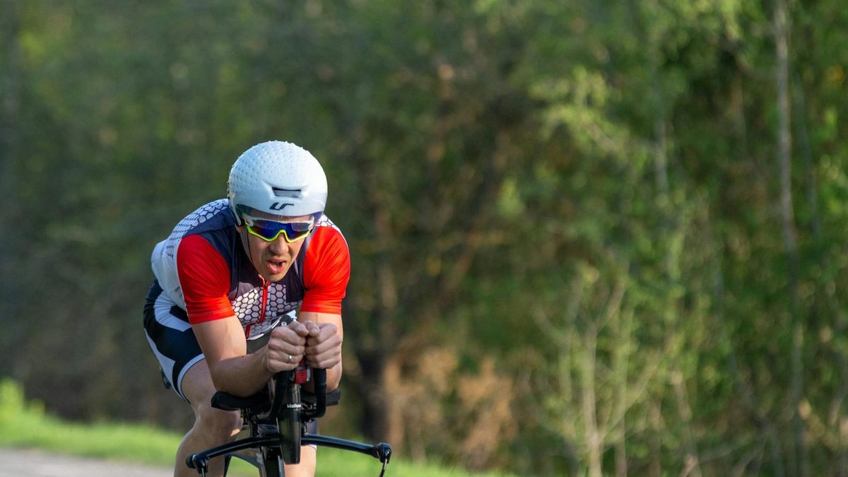 Triathlète sur vélo de contre-la-montre en position aéro sur route