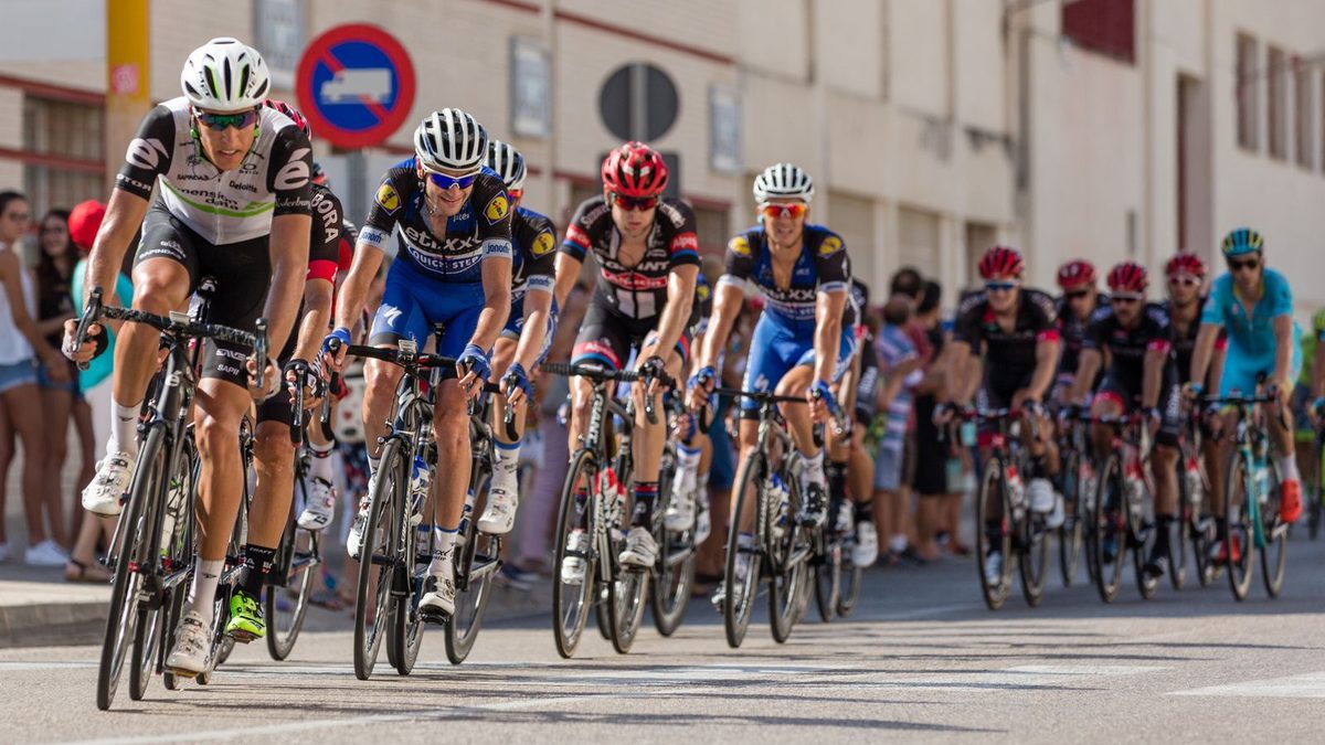 Peloton de coureurs en pleine course sur route, comparatif des marques Cervélo et BMC pour la compétition