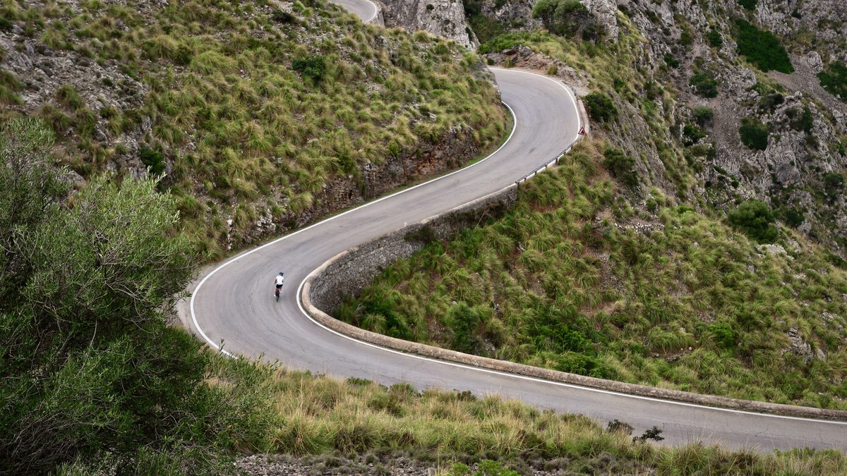 Cycliste de route seul dans un lacet de montagne, vue aérienne
