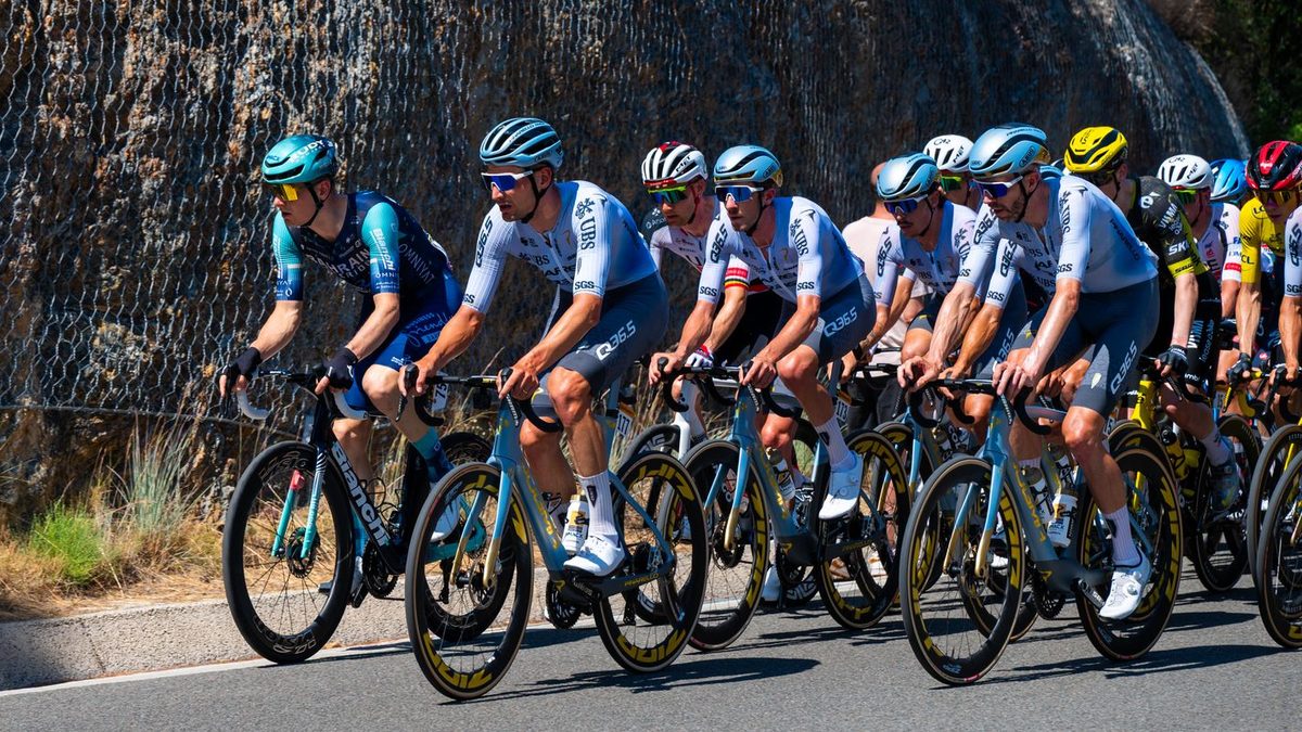 Peloton de cyclistes en maillot et cuissard sur route ensoleillée