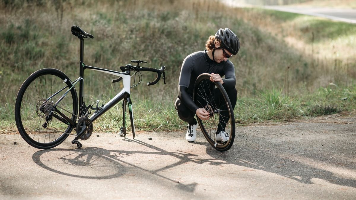 Cycliste réparant un pneu de vélo de route en pleine campagne