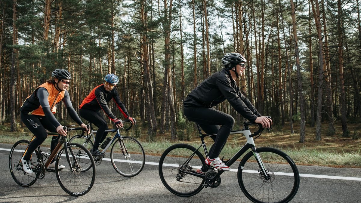 Cyclistes roulant côte à côte sur une route de campagne à l'aise sur leurs vélos endurance