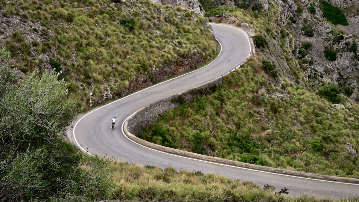 Cycliste sur route de montagne en vue aérienne