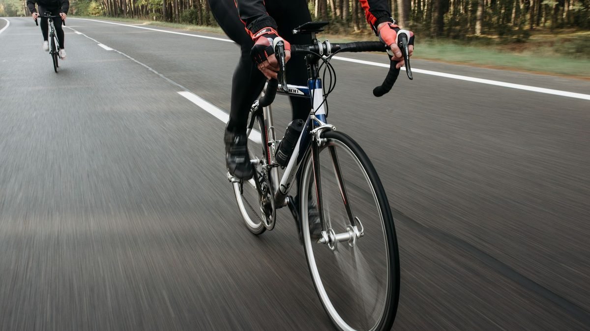 Cycliste en tenue d'hiver sur une route enneigée